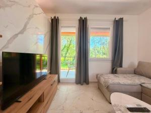 a living room with a flat screen tv and a couch at Captain's Oasis in Budva