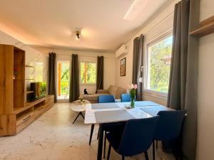 a living room with a table and blue chairs at Captain's Oasis in Budva