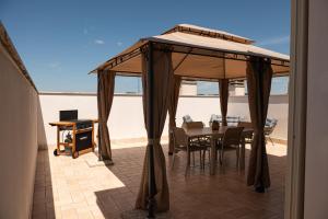 a gazebo on a patio with a table and chairs at Domus Home Ladispoli in Ladispoli