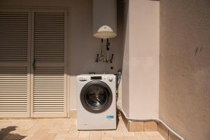a washing machine in the corner of a room at Domus Home Ladispoli in Ladispoli +51 photos
