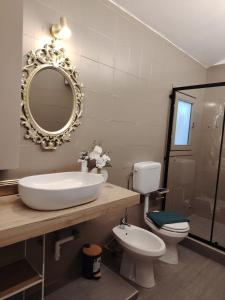 a bathroom with a sink and a toilet and a mirror at Domus Mater in Vigonza