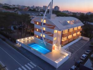 a building with a swimming pool in front of a street at Residence Silver Sail in Bibione