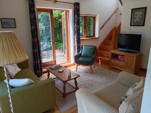 a living room with a couch and a tv at Fig Tree Cottage in Dursley