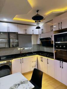 a kitchen with white cabinets and a black counter top at North Unit in Asaba