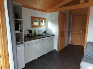 a kitchen with white cabinets and a counter top at Camping Le Sans Souci in Fresnay-sur-Sarthe