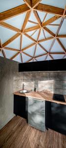 a kitchen with a sink and a wooden ceiling at Dôme Diem luxe climatisé in Lesterps