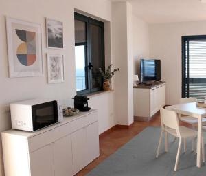 a living room with a microwave and a table at Il Corbezzolo Tropea Residence in Tropea