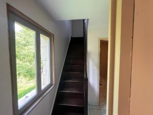 a staircase in a house with a window at Appartement indépendant dans maison en pierre in Coeuvres-et-Valsery