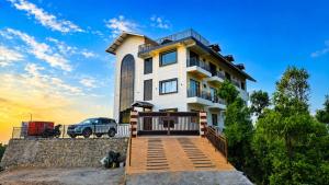 a house with a car parked in front of it at Dharamshila Retreat in Chakrāta