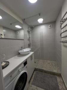 a bathroom with a washing machine and a sink at Taikos apartments in Kupiškis