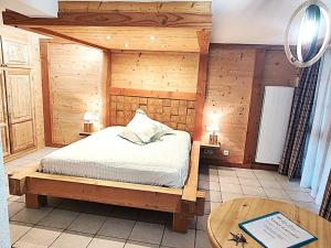 a bedroom with a bed and a wooden wall at Maison d'hôtes La Cerisaie in Breitenbach