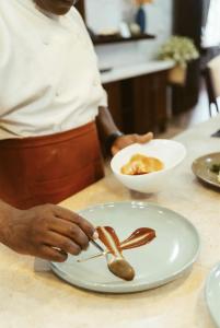 a chef preparing a plate of food on a counter at Sharuu Residency in Msaranga