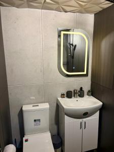a bathroom with a toilet and a sink and a mirror at AZURA one in Varna City +35 photos