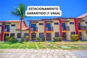a building with a palm tree in front of it at Casa Residencial Jerusalém II in Santa Cruz Cabrália