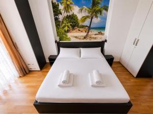 a bed in a room with a picture of a beach at Coralia Luna Park Apartments in Mamaia