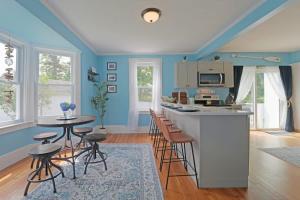 a kitchen with blue walls and a table and stools at Beautiful Modern Beach House! in Old Orchard Beach +28 photos