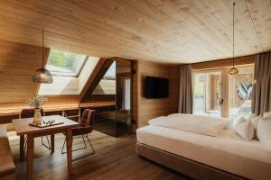 a bedroom with a large bed and a desk and a table at Hotel Spielmann 4s in Ehrwald
