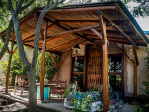 a wooden pergola on the side of a house at Gran Cabaña con parque en Catamarca in San Fernando del Valle de Catamarca