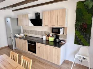 a kitchen with wooden cabinets and a black counter top at Casa Magda - Oaza de Relaxare in Călimăneşti