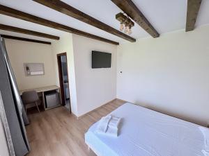 a bedroom with a white bed and a desk at Casa Magda - Oaza de Relaxare in Călimăneşti +16 photos