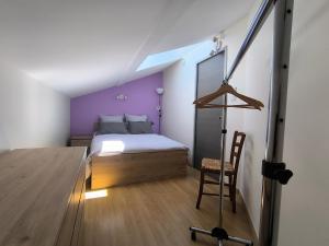 a bedroom with a bed with a purple wall at Feutres et Formes in Bourg-de-Péage