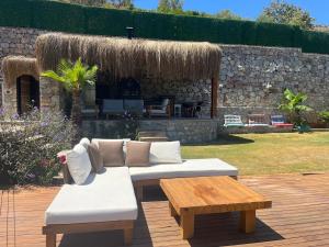 a patio with a white couch and a wooden table at Villa Han Selimiye in Selimiye