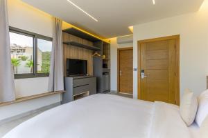 a bedroom with a large bed and a television at Cavella Apart Hotel in Monsef in Al Ḩulwah