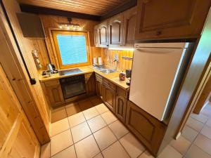 a small kitchen with wooden cabinets and a refrigerator at Jagdhütte in Zöllnitz