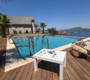 a white table sitting on a deck next to a swimming pool at Villa Han Selimiye in Selimiye