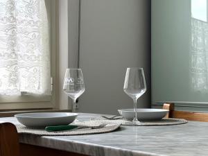 a table with two wine glasses and plates on it at Bilocale a 500m dal mare in Giulianova +6 photos