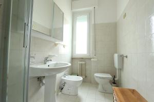 a white bathroom with a sink and a toilet at Bilocale a 500m dal mare in Giulianova