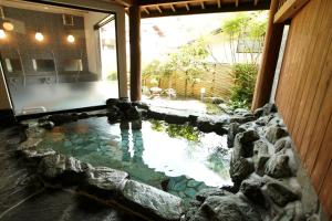 a pool of water in the middle of a house at Irorino Yado Sankichi in Izu