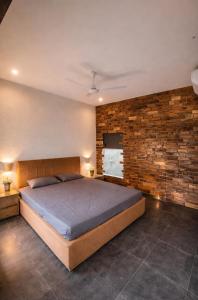 a bedroom with a bed and a brick wall at Mount Magica - Refined By Nature in Rānchī