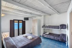 a bedroom with two bunk beds and a balcony at Tenuta Donna Carmela in Pisciotta
