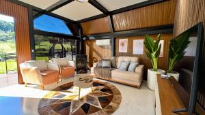 a living room with a couch and a table at Cabana Silêncio das Pedras in Três Coroas