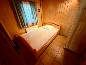 a small bed in a room with a window at Jagdhütte in Zöllnitz