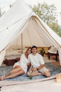 a man and woman sitting on a rug under a tent at Täheonni Glämping in Tautsa