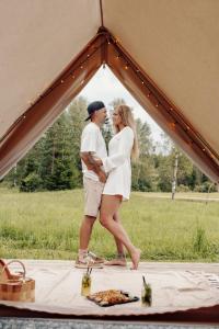 a man and woman standing inside of a tent at Täheonni Glämping in Tautsa