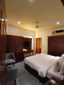 a bedroom with a bed and a desk and a chair at The Elet Express Luxury Hotel Apartments in Karachi +13 photos