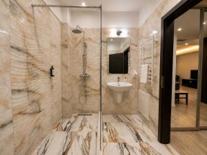 a bathroom with a shower and a sink at Coralia Luna Park Apartments in Mamaia +161 photos