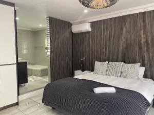 a bedroom with a large bed and a bathroom at Reef View BnB in East London