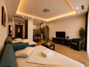a hotel room with two beds and a television at Coralia Luna Park Apartments in Mamaia