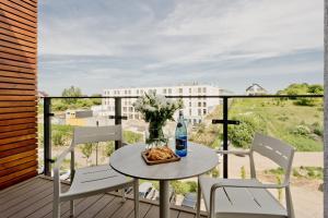 a table with a vase of flowers on a balcony at Aparthotel Anchoria BlueApart in Mechelinki
