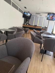 a waiting room with chairs and tables and a tv at Bume's Hostel in Sarandë