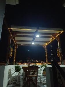 eine Terrasse mit weißen Stühlen, einem Tisch und Lichtern in der Unterkunft Lissia Hotel in Skala Eresou + 3 Fotos