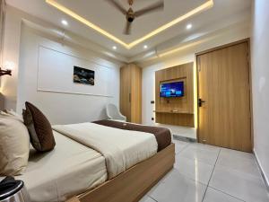 a bedroom with a large bed and a tv at Atithi in Hisār