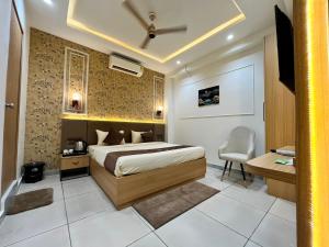 a bedroom with a bed and a desk and a chair at Atithi in Hisār +12 photos