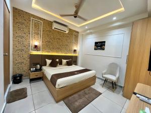 a bedroom with a bed and a chair in it at Atithi in Hisār