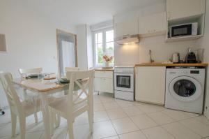 a kitchen with a table and a kitchen with a washing machine at La bulle champêtre in Balnot-sur-Laignes +5 photos