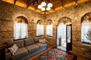 a living room with a couch and windows at Valaes Guest House in Foiníkion